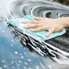 Hand washing a car with soapy water, emphasizing windshield care and maintenance for Florida drivers.