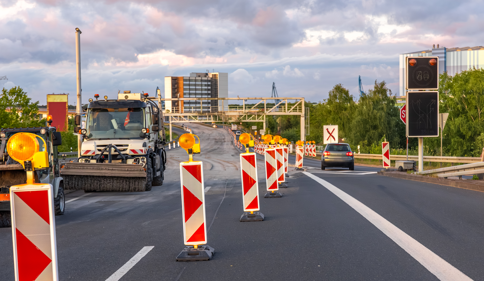 Road construction scene with traffic barriers, warning lights, and a construction vehicle, illustrating maintenance efforts affecting Florida drivers' windshields.